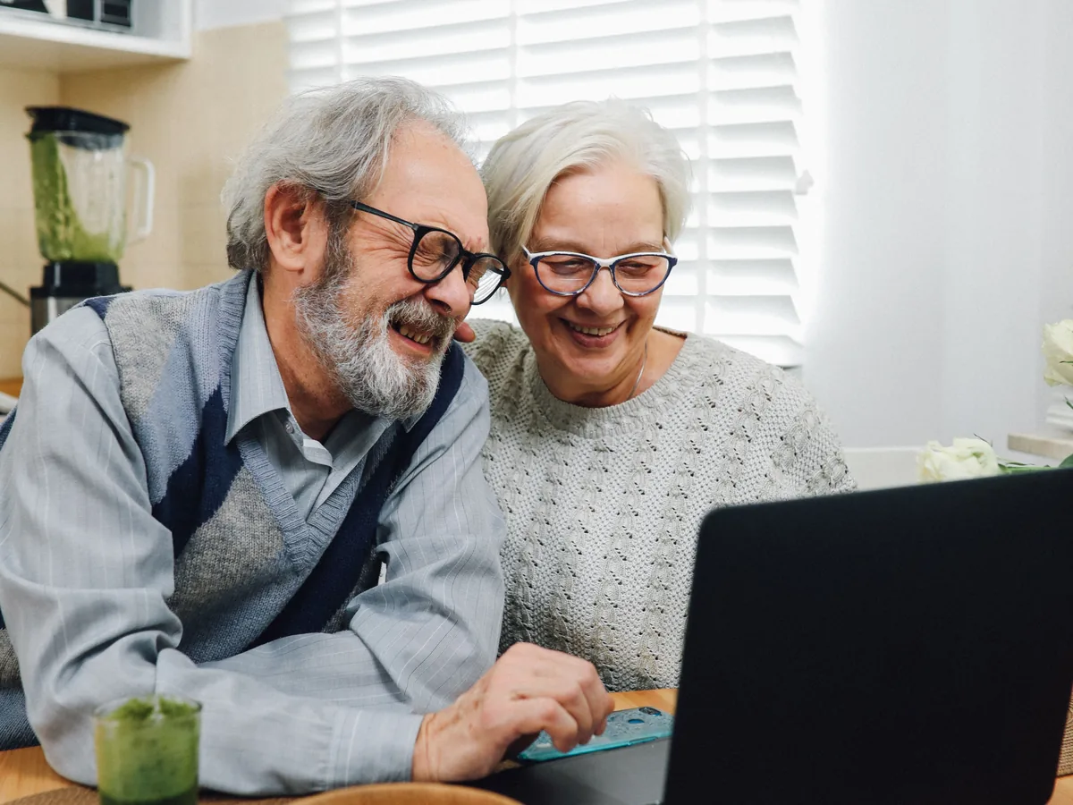 Couple senior échangeant sereinement autour de documents